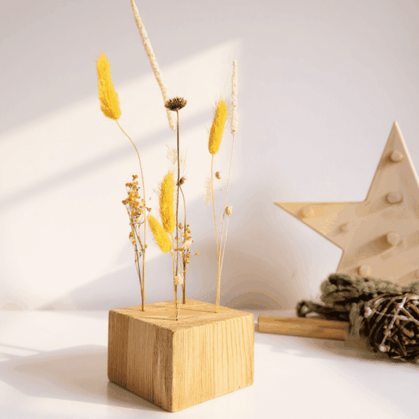 Cubo de madera con flores secas amarillas y blancas. Pieza decorativa natural y minimalista